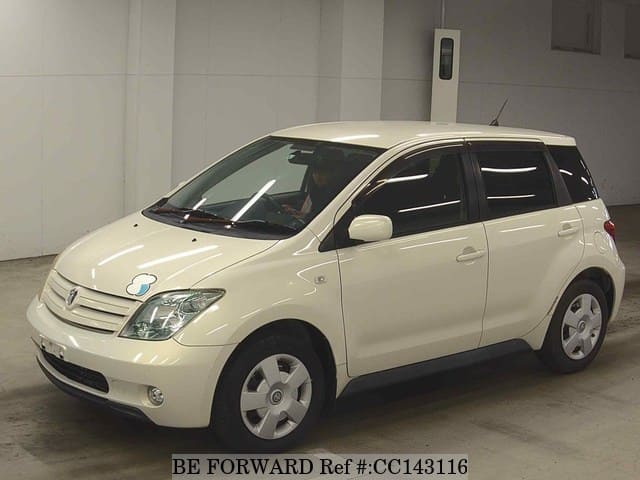 A grey sports car speeding down a highway at night.