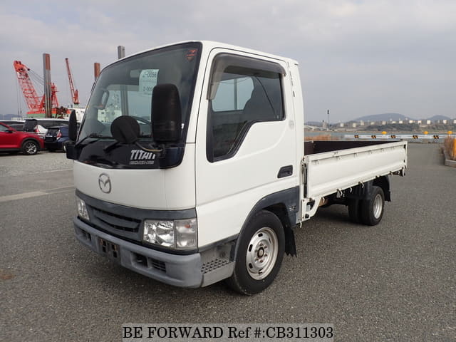 A grey JDM sports car speeding down a highway at night.