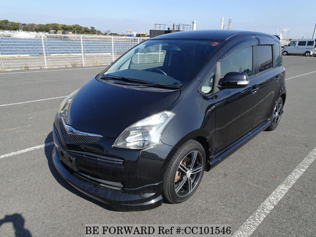 A grey sports car speeding down a highway at night.