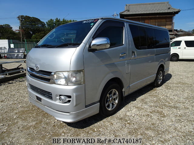 A grey JDM sports car speeding down a highway at night.