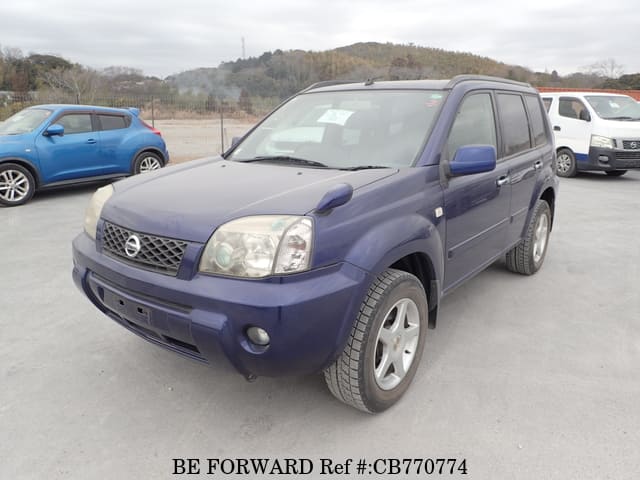 A grey JDM sports car speeding down a highway at night.