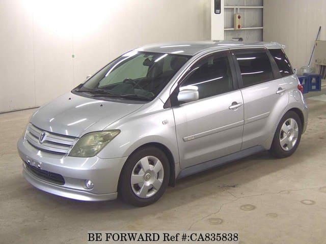 A grey JDM sports car speeding down a highway at night.