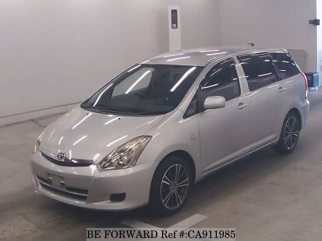 A grey JDM sports car speeding down a highway at night.