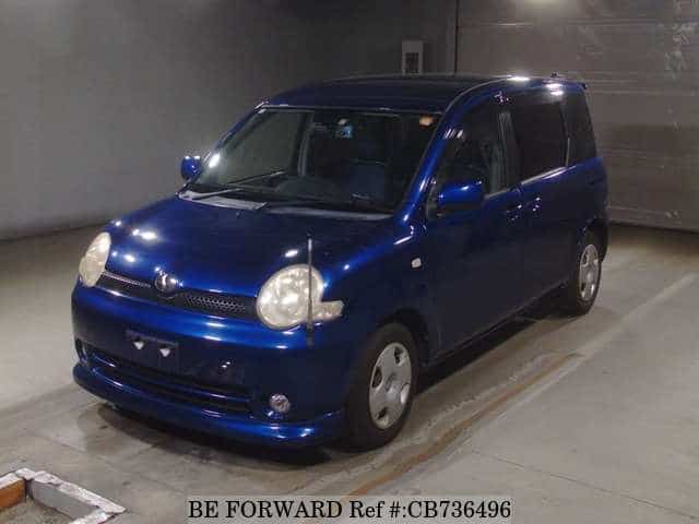 A grey JDM sports car speeding down a highway at night.