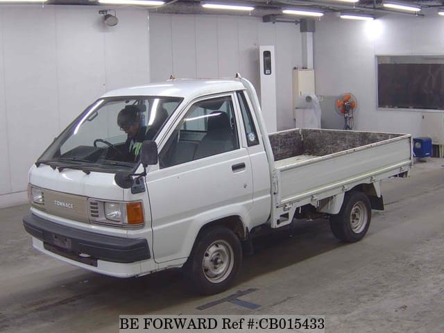 A grey JDM sports car speeding down a highway at night.