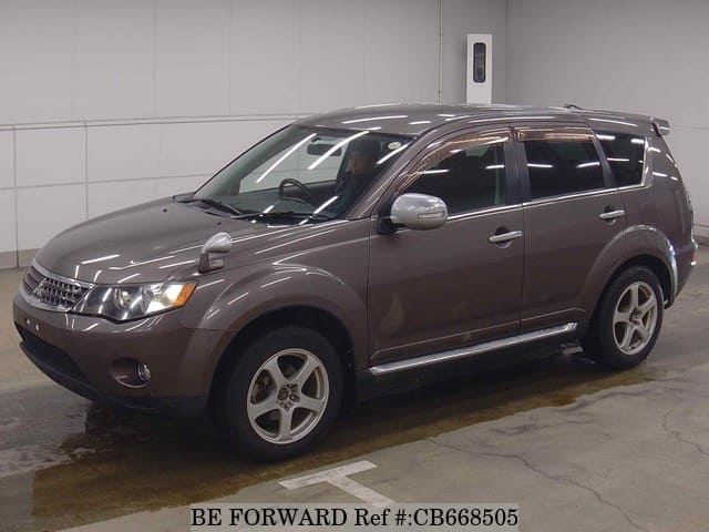 A grey JDM sports car speeding down a highway at night.