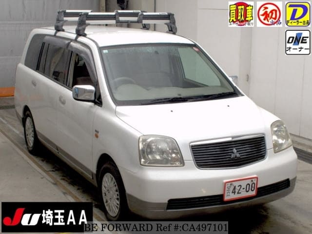 A grey JDM sports car speeding down a highway at night.