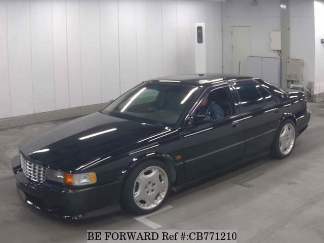 A grey JDM sports car speeding down a highway at night.