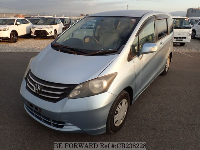 A grey JDM sports car speeding down a highway at night.