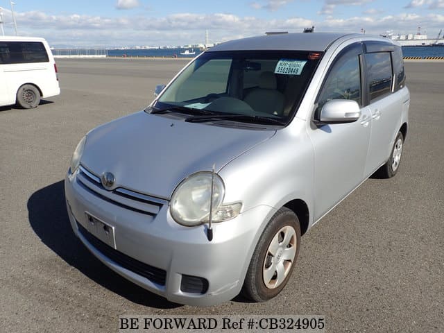 A grey JDM sports car speeding down a highway at night.