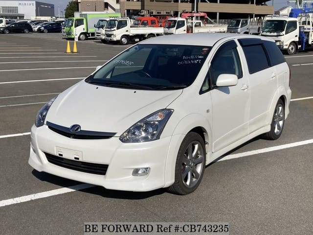 A grey JDM sports car speeding down a highway at night.