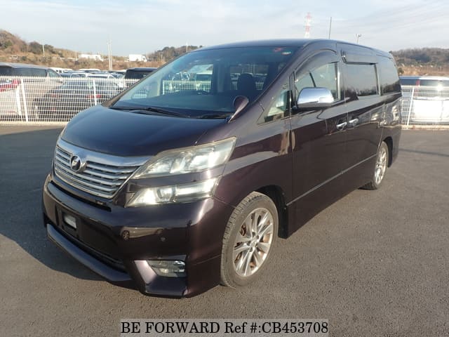 A grey JDM sports car speeding down a highway at night.