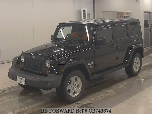 A grey JDM sports car speeding down a highway at night.