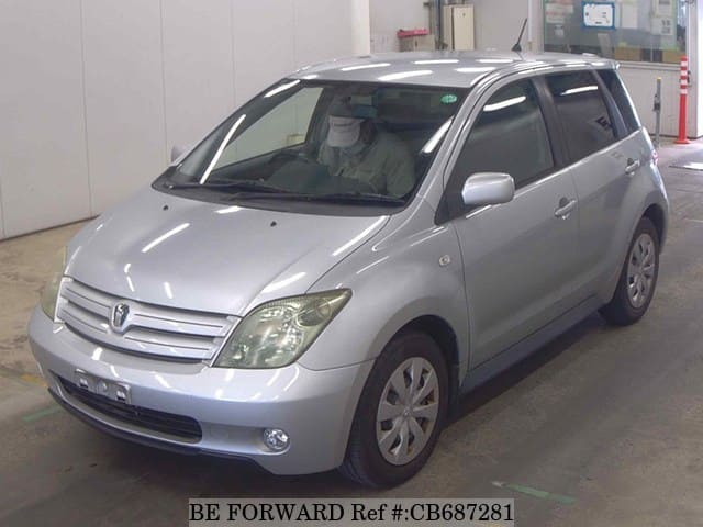A grey JDM sports car speeding down a highway at night.