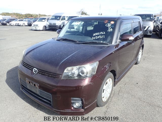 A grey JDM sports car speeding down a highway at night.