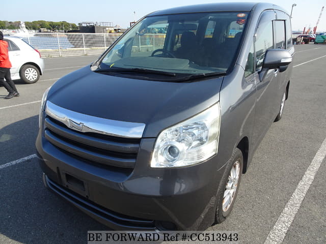 A grey sports car speeding down a highway at night.