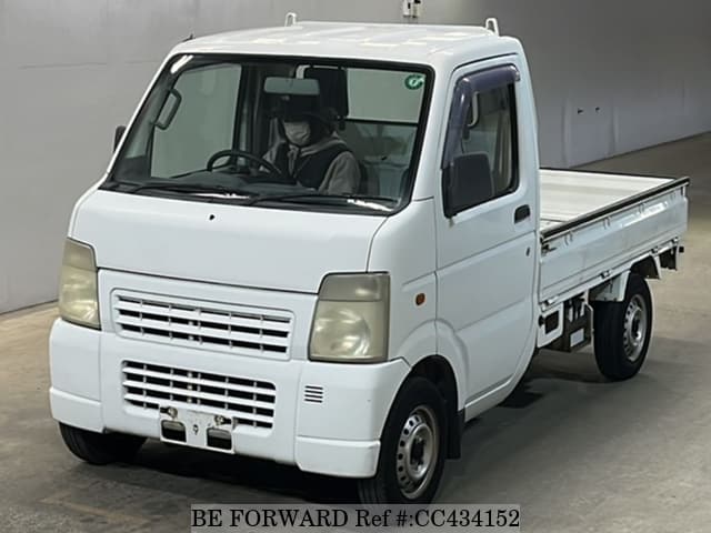 A grey sports car speeding down a highway at night.