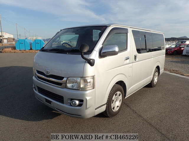 A grey JDM sports car speeding down a highway at night.