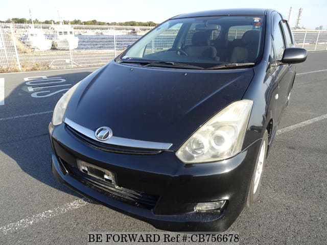 A grey JDM sports car speeding down a highway at night.