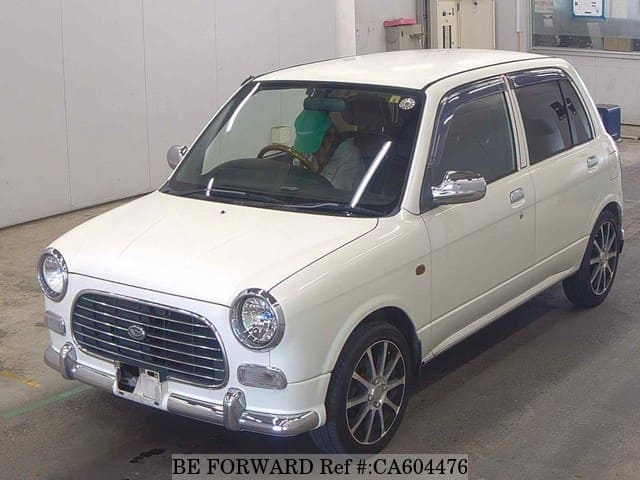 A grey JDM sports car speeding down a highway at night.