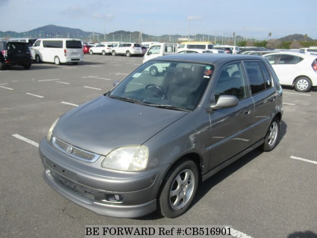 A grey JDM sports car speeding down a highway at night.