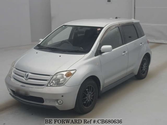 A grey JDM sports car speeding down a highway at night.