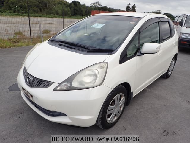 A grey JDM sports car speeding down a highway at night.