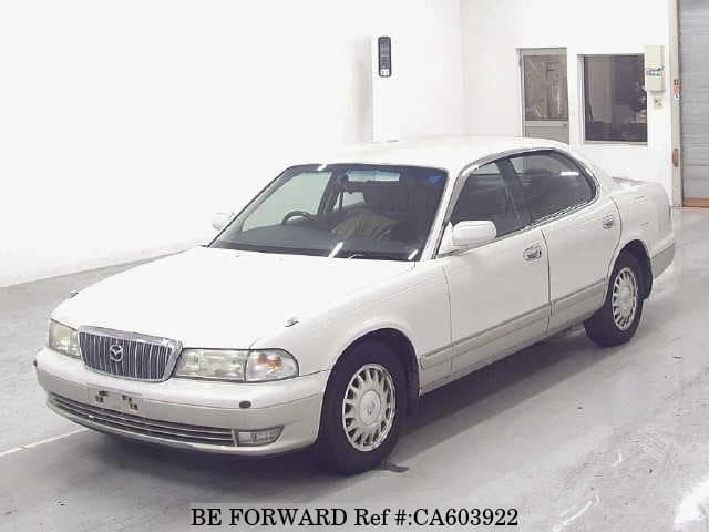 A grey JDM sports car speeding down a highway at night.