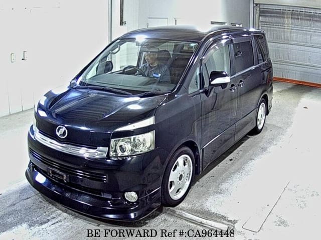 A grey JDM sports car speeding down a highway at night.