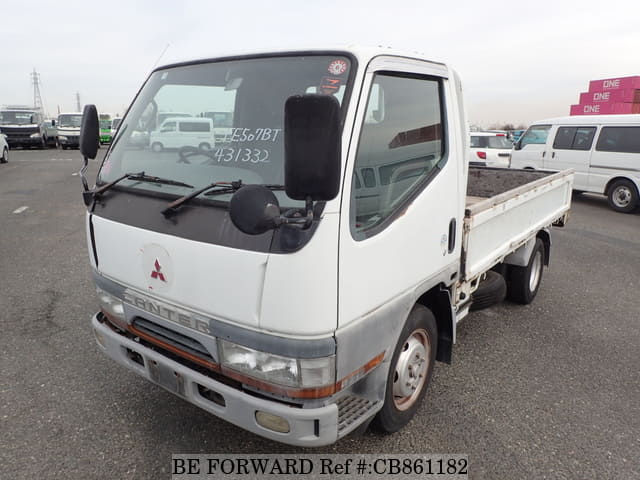 A grey sports car speeding down a highway at night.