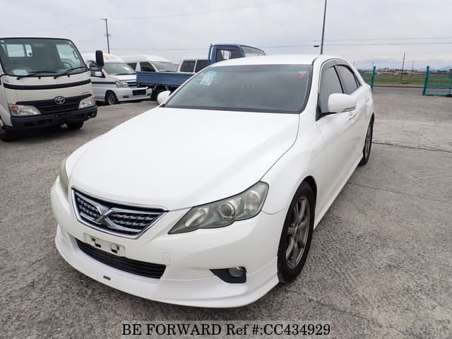 A grey JDM sports car speeding down a highway at night.