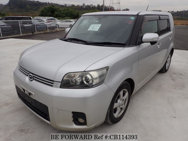 A grey JDM sports car speeding down a highway at night.