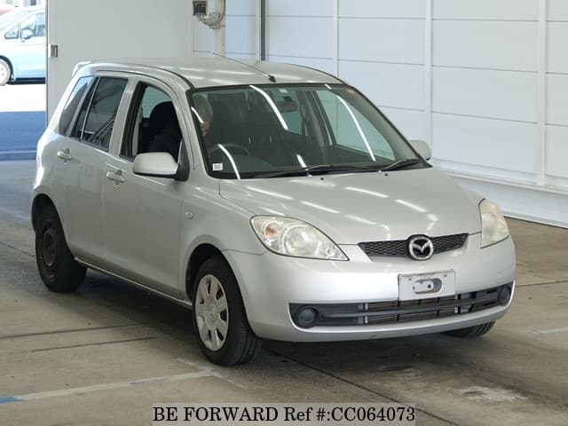 A grey sports car speeding down a highway at night.
