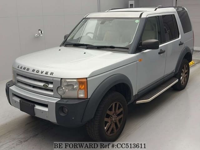 A grey sports car speeding down a highway at night.