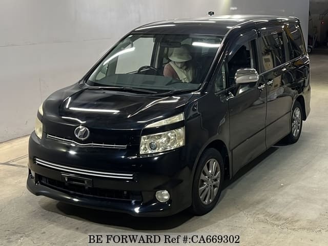 A grey JDM sports car speeding down a highway at night.