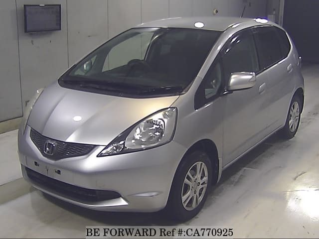 A grey JDM sports car speeding down a highway at night.