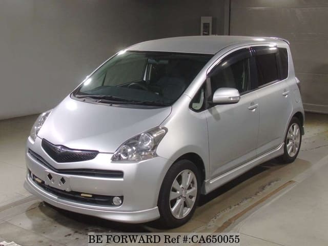 A grey JDM sports car speeding down a highway at night.