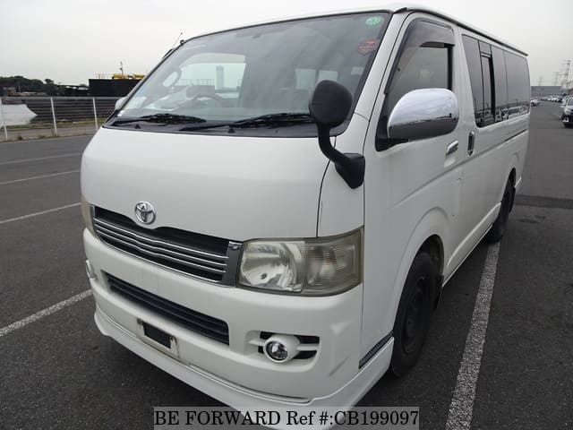 A grey sports car speeding down a highway at night.