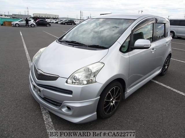 A grey JDM sports car speeding down a highway at night.