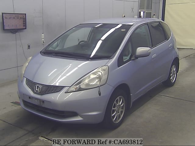 A grey JDM sports car speeding down a highway at night.