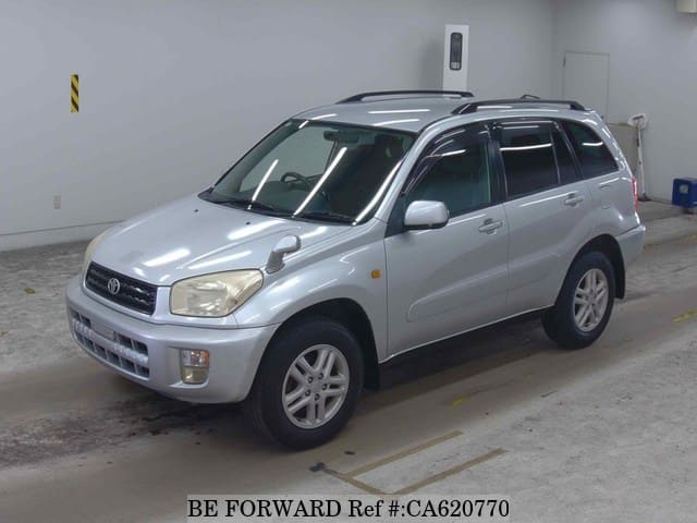 A grey JDM sports car speeding down a highway at night.