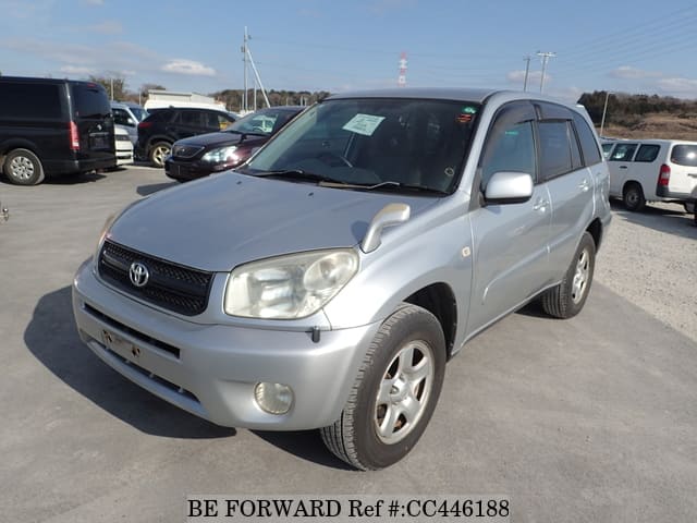 A grey JDM sports car speeding down a highway at night.