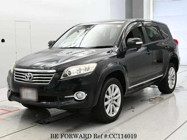 A grey sports car speeding down a highway at night.