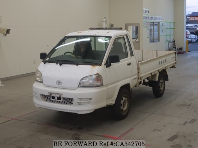 A grey JDM sports car speeding down a highway at night.