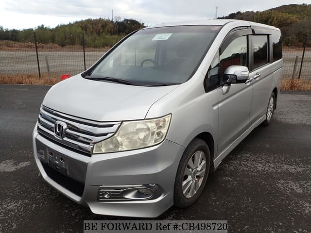 A grey JDM sports car speeding down a highway at night.