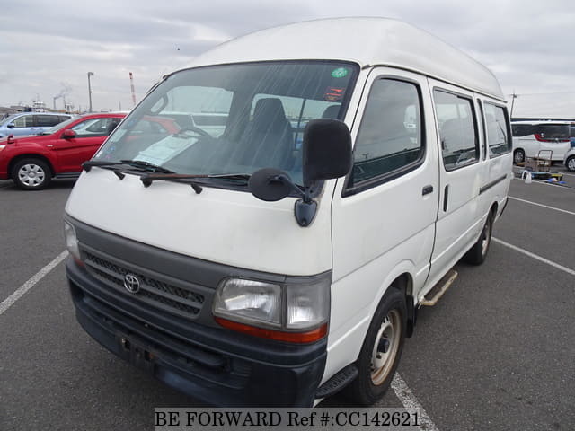 A grey sports car speeding down a highway at night.