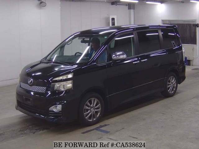 A grey JDM sports car speeding down a highway at night.