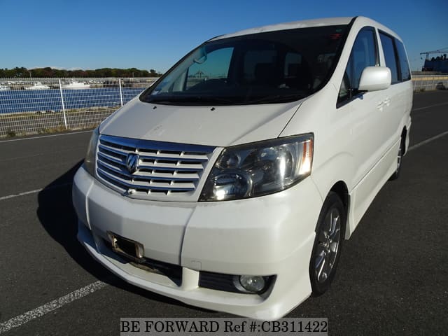A grey JDM sports car speeding down a highway at night.