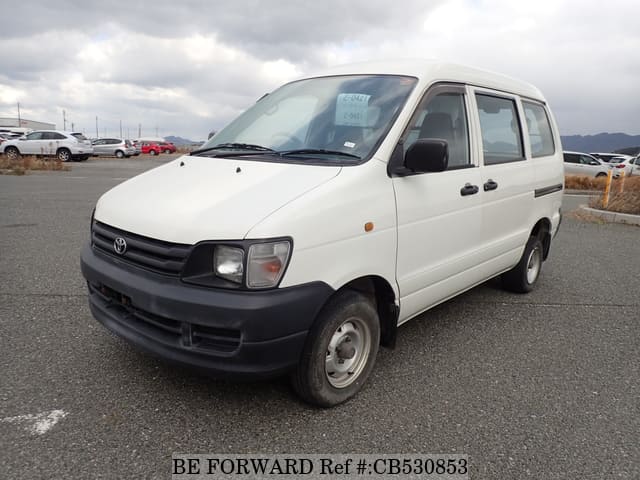 A grey JDM sports car speeding down a highway at night.