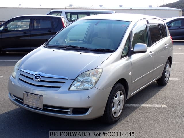 A grey sports car speeding down a highway at night.